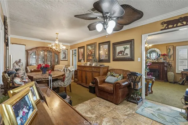 a living room with furniture a chandelier and a flat screen tv