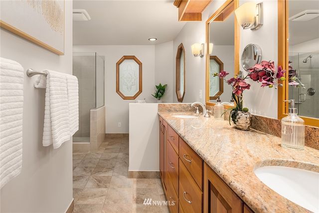 a bathroom with a granite countertop sink a mirror and a shower