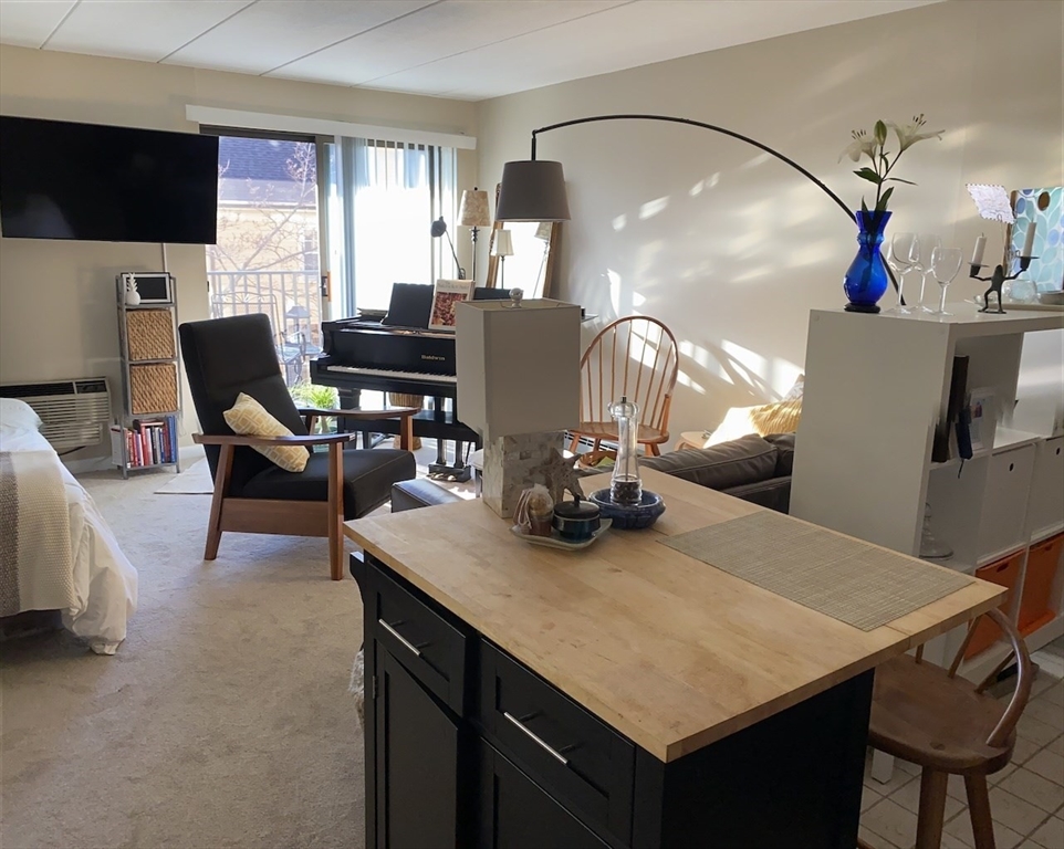 60 Pleasant Street, Unit 211 Arlington, MA 02476 - Photo 1 of 12 a dining room with furniture and a flat screen tv