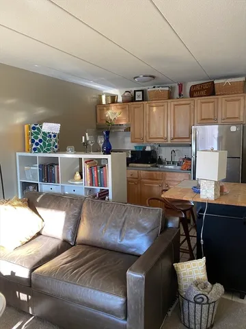 a living room with stainless steel appliances kitchen island granite countertop furniture and a kitchen view