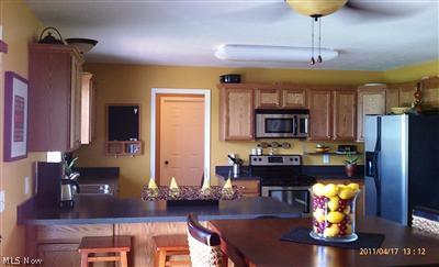 63 Bandy Road North Benton, OH 44449 - Photo 6 of 20 Very spacious and open kitchen/great room concept. Modern colors. Plenty of cabinet storage. Ceiling fan above eat-in area. Appliances remain. Slider to the left of picture, opens to large deck.