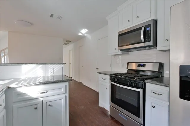 a kitchen with granite countertop cabinets and steel stainless steel appliances
