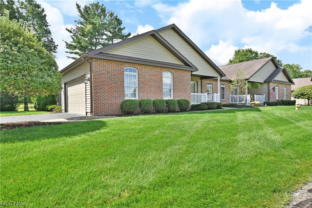 2033 East River Road, Unit 11 Newton Falls, OH 44444 - Photo 32 of 35 View of front of home with garage, a porch, and a front lawn