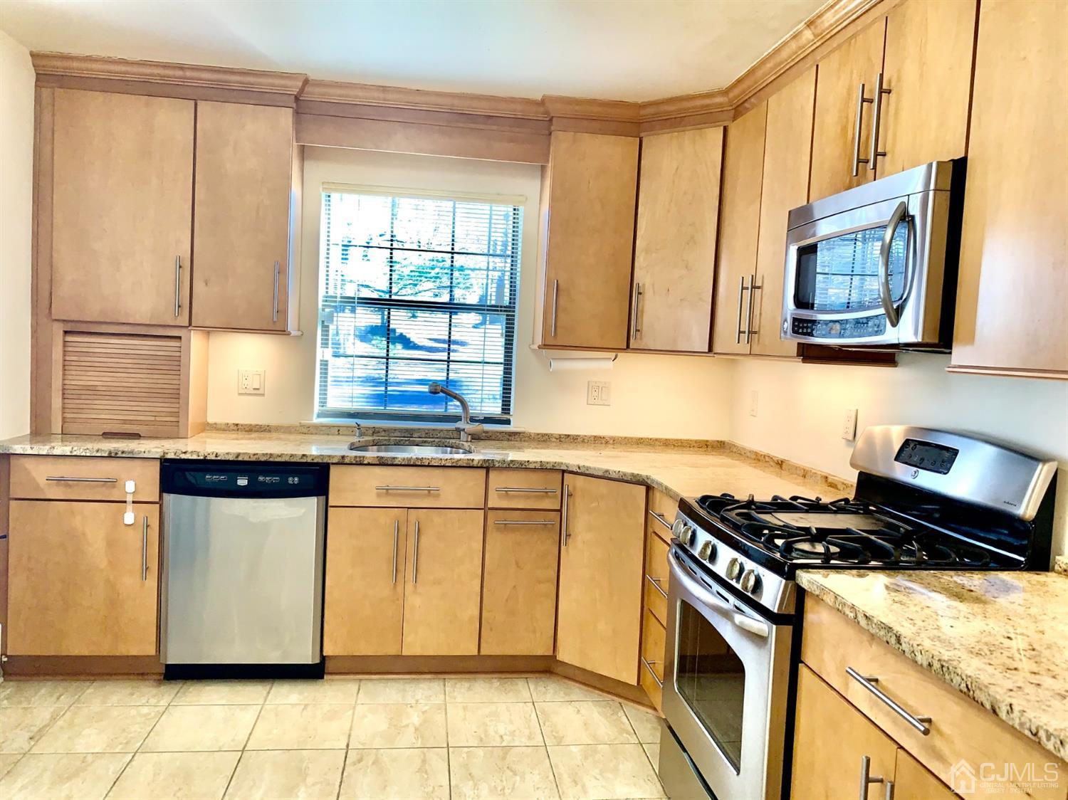 1001 Timber Oaks Road, Unit 1001 Edison, NJ 08820 - Photo 14 of 25 a kitchen with stainless steel appliances granite countertop a stove a sink and a microwave