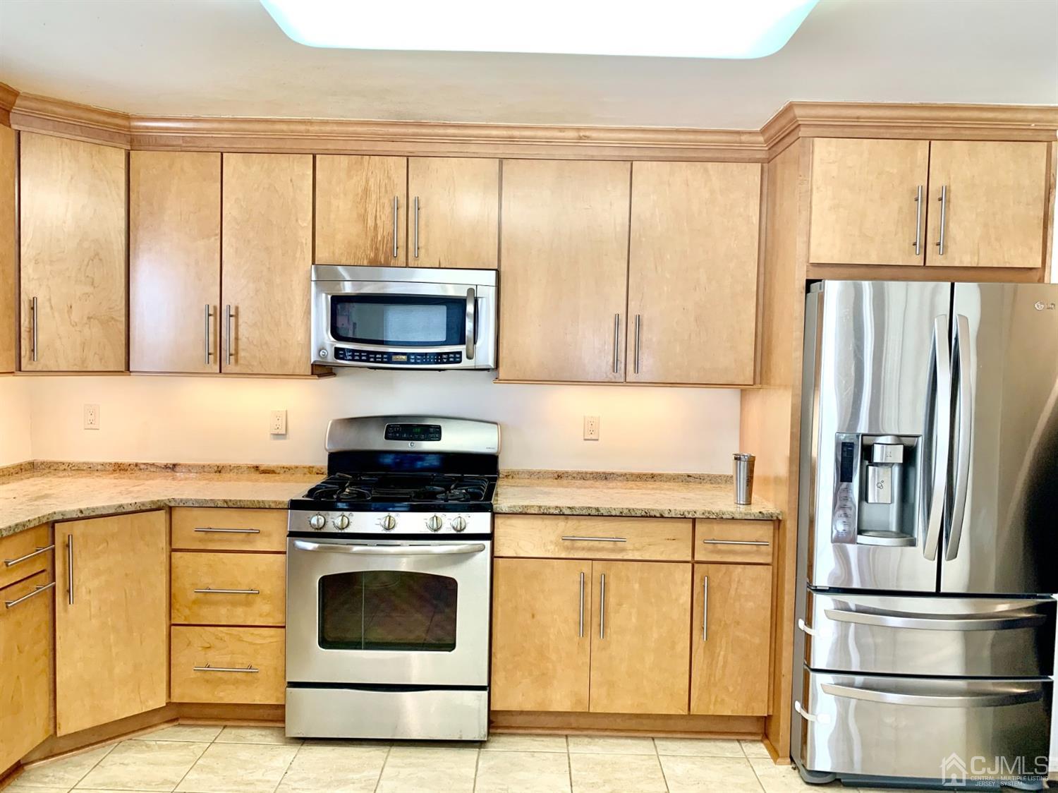 1001 Timber Oaks Road, Unit 1001 Edison, NJ 08820 - Photo 15 of 25 a kitchen with a stove a microwave and a refrigerator