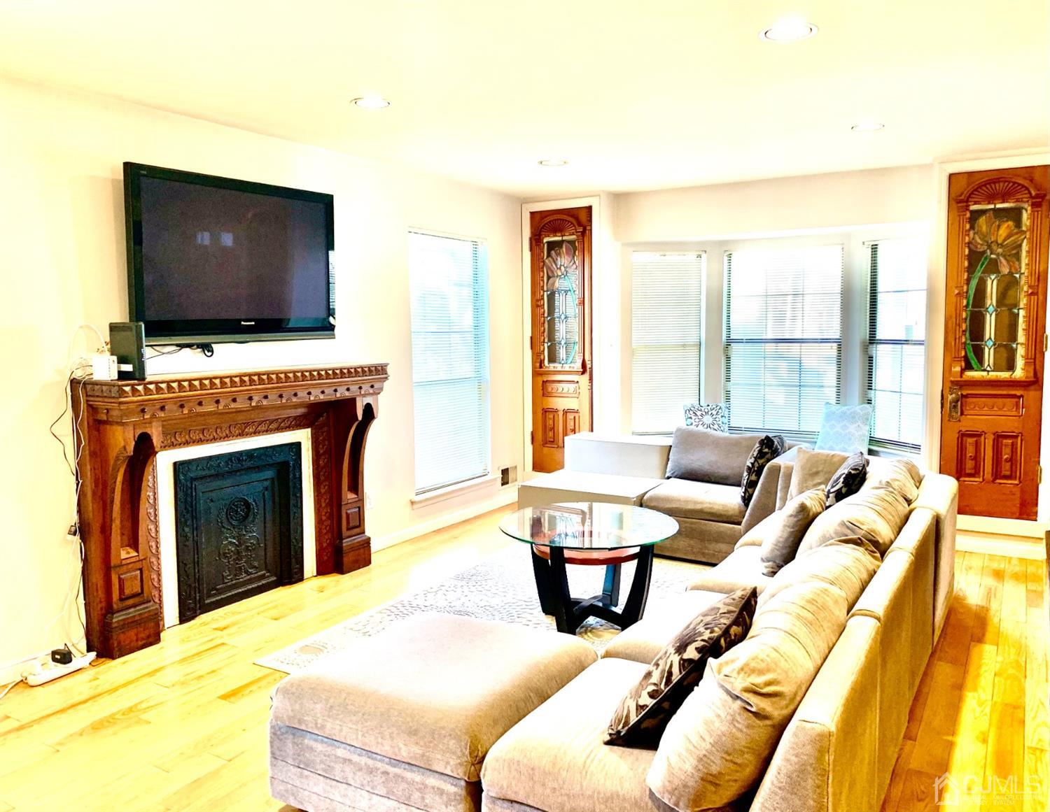 1001 Timber Oaks Road, Unit 1001 Edison, NJ 08820 - Photo 9 of 25 a living room with furniture a flat screen tv and a fireplace