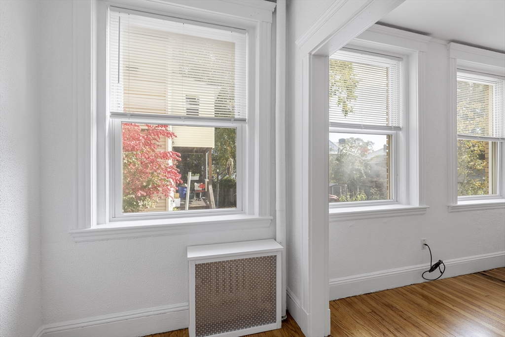 170 Maple Street, Unit 110 Malden, MA 02148 - Photo 13 of 23 a view of an empty room with wooden floor and a window
