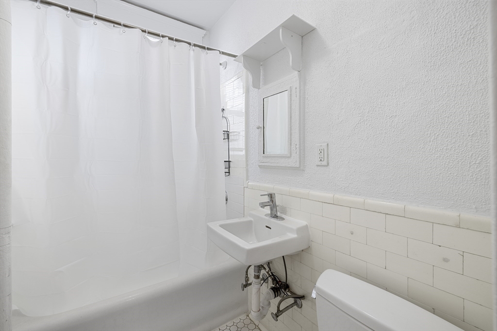 170 Maple Street, Unit 110 Malden, MA 02148 - Photo 6 of 23 a bathroom with a sink a mirror and a toilet