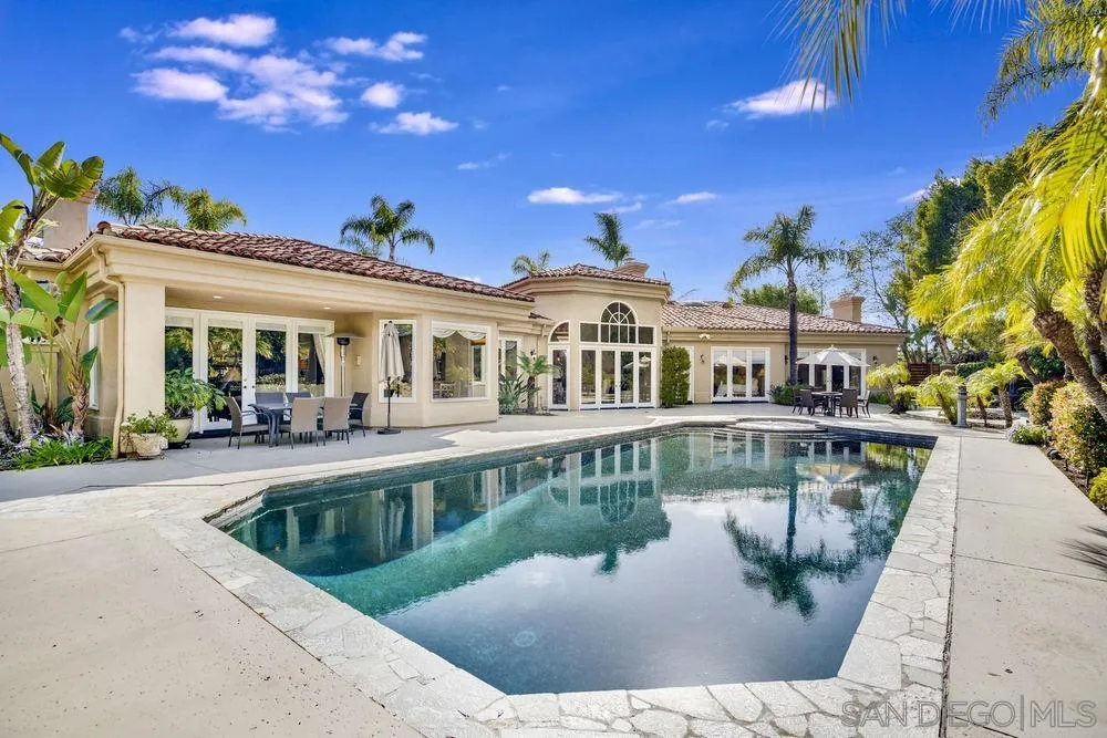 7745 St Andrews Road Rancho Santa Fe, CA 92067 - Photo 4 of 29 a view of a white house with swimming pool and sitting area