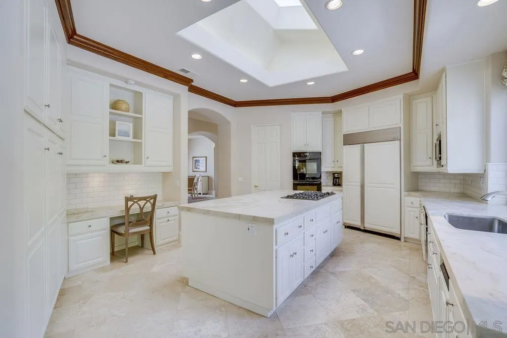 7745 St Andrews Road Rancho Santa Fe, CA 92067 - Photo 8 of 29 a large white kitchen with cabinets and stainless steel appliances