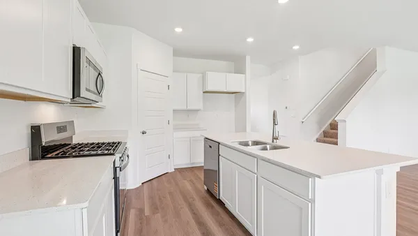 a kitchen that has a lot of cabinets in it and wooden floors