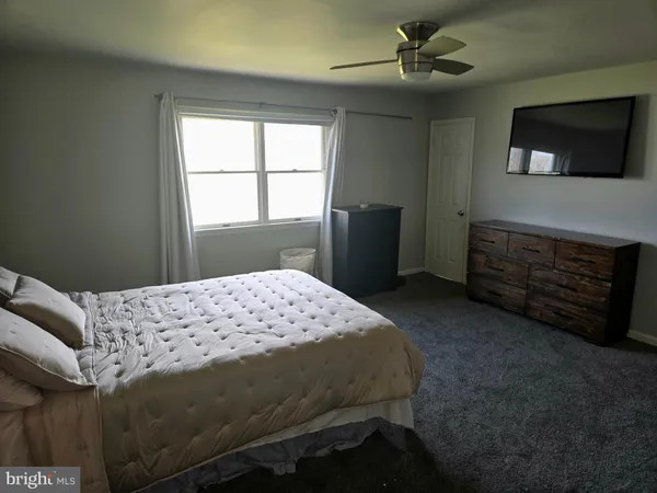 a bedroom with a bed dresser and a window