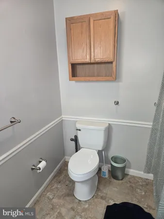 a bathroom with a toilet and a mirror