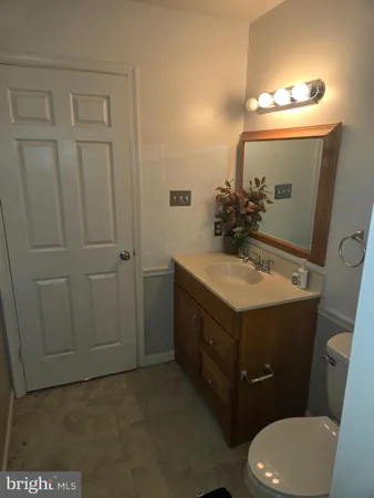 a bathroom with a sink vanity mirror and toilet