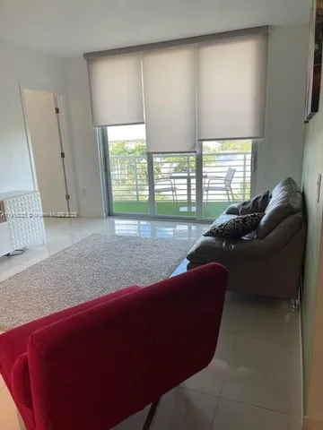 a living room with furniture and a floor to ceiling window