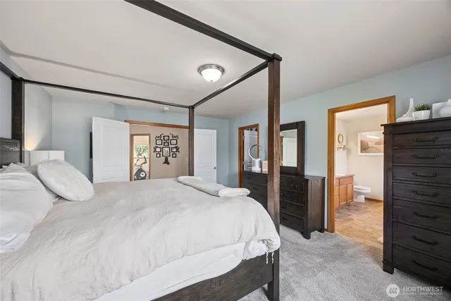 a bedroom with a large bed and wooden floor