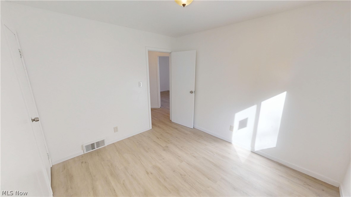 693 Liberty Road Youngstown, OH 44505 - Photo 8 of 14 Wood-finish flooring with white baseboards, white walls, and a ceiling-mounted light fixture