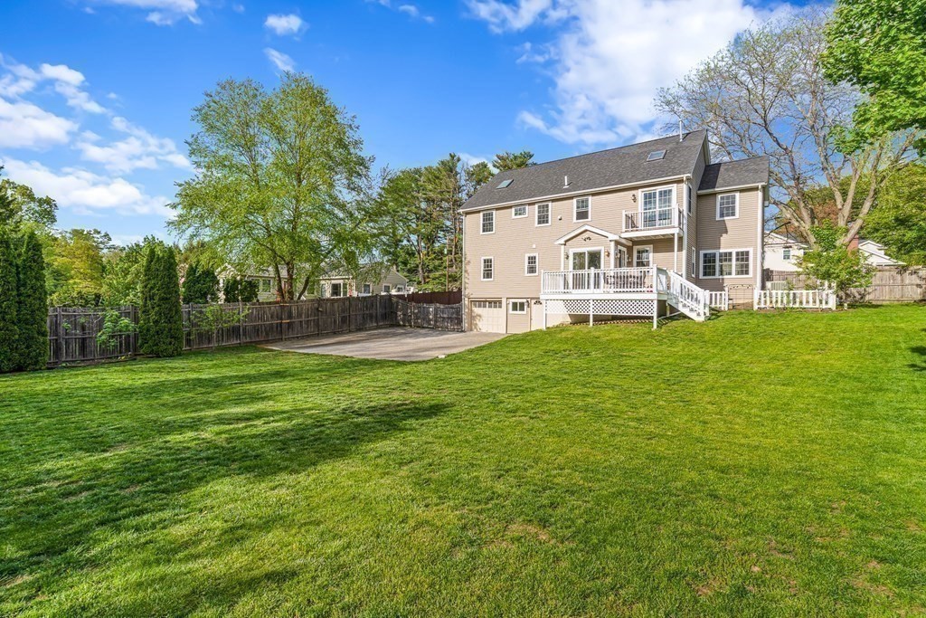 a view of a white house with a big yard and large trees