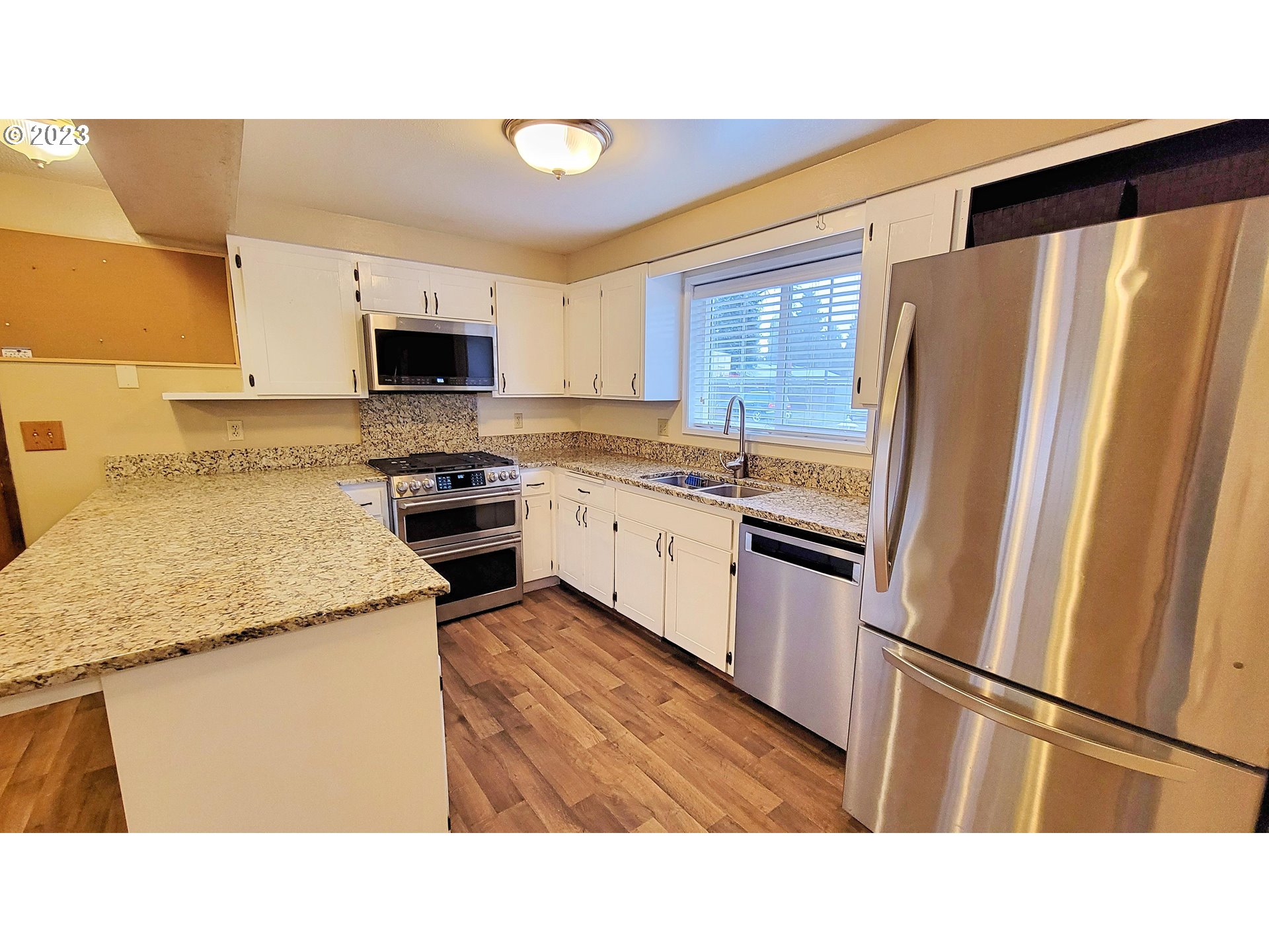 726 Rayner Avenue Springfield, OR 97477 - Photo 2 of 19 a kitchen with stainless steel appliances granite countertop a refrigerator a stove a sink and a microwave