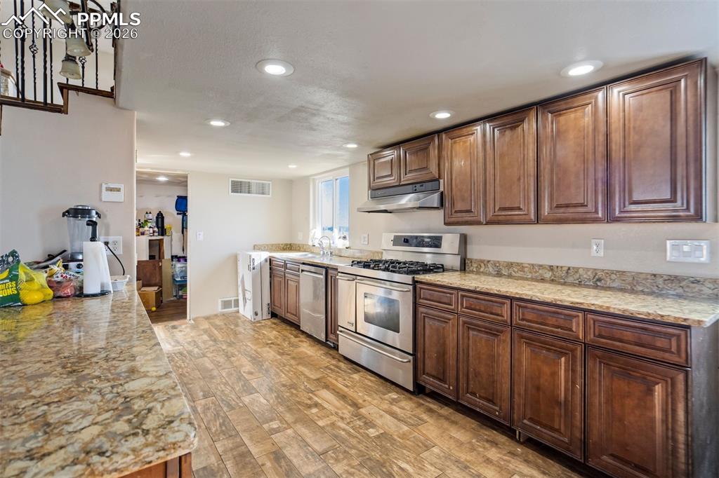14050 Davis Road Peyton, CO 80831 - Photo 9 of 50 a kitchen with stainless steel appliances granite countertop a stove sink and cabinets