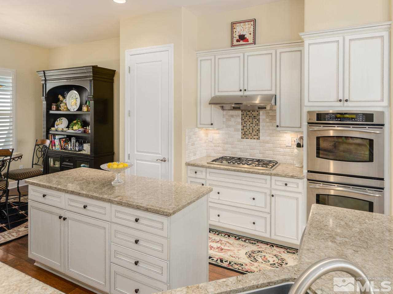 1075 Meridian Ranch Drive Reno, NV 89523 - Photo 8 of 25 a kitchen with granite countertop white cabinets and appliances