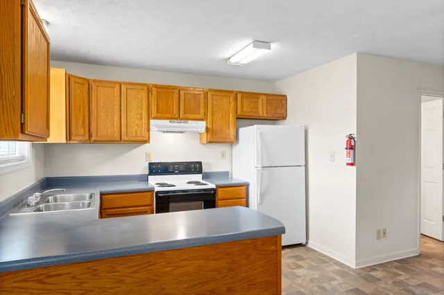 a kitchen with stainless steel appliances granite countertop a refrigerator a stove and a sink