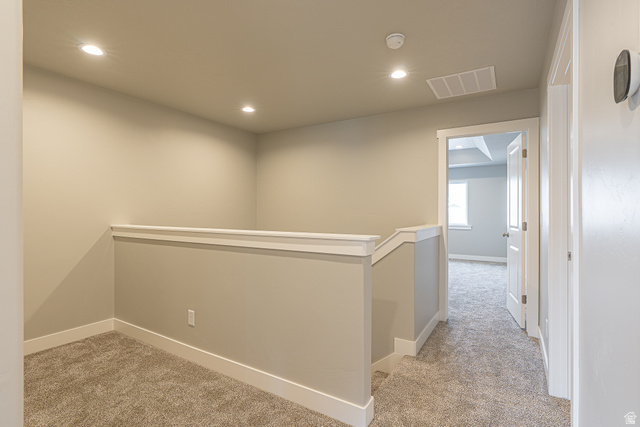 2257 South 1090 West, Unit 74 Nibley, UT 84321 - Photo 8 of 40 Carpeted upper level landing with a painted half-wall railing, recessed ceiling lights, and light gray wall paint