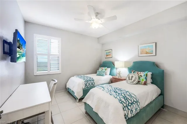 a bedroom with two beds and a chandelier