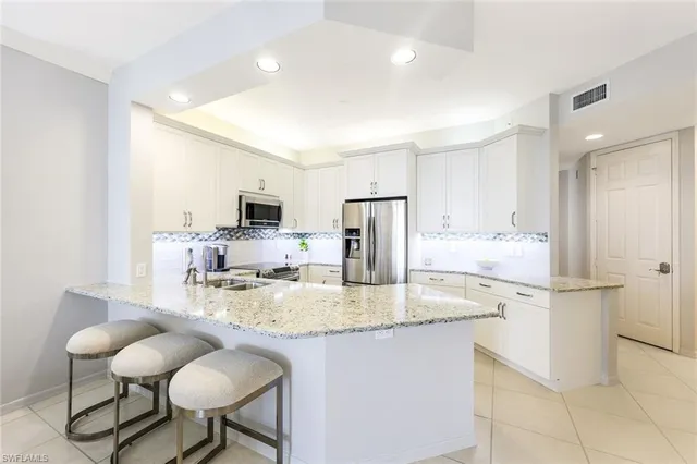 a kitchen with kitchen island a counter top space appliances and cabinets