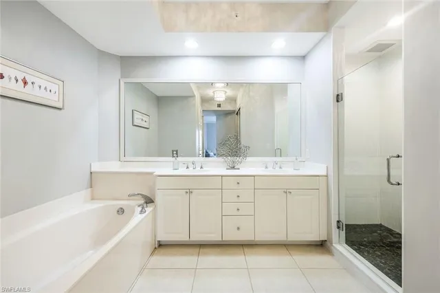 a bathroom with a tub sink shower and mirror