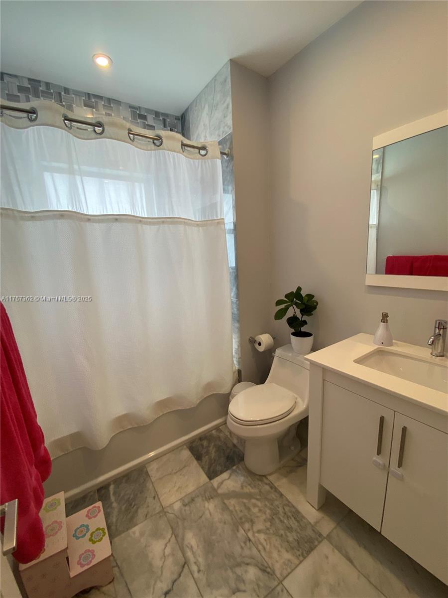 790 Southwest 21st Road Miami, FL 33129 - Photo 36 of 83 a bathroom with a granite countertop sink mirror vanity and toilet