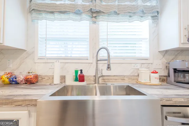a kitchen with stainless steel appliances a sink a window and cabinets