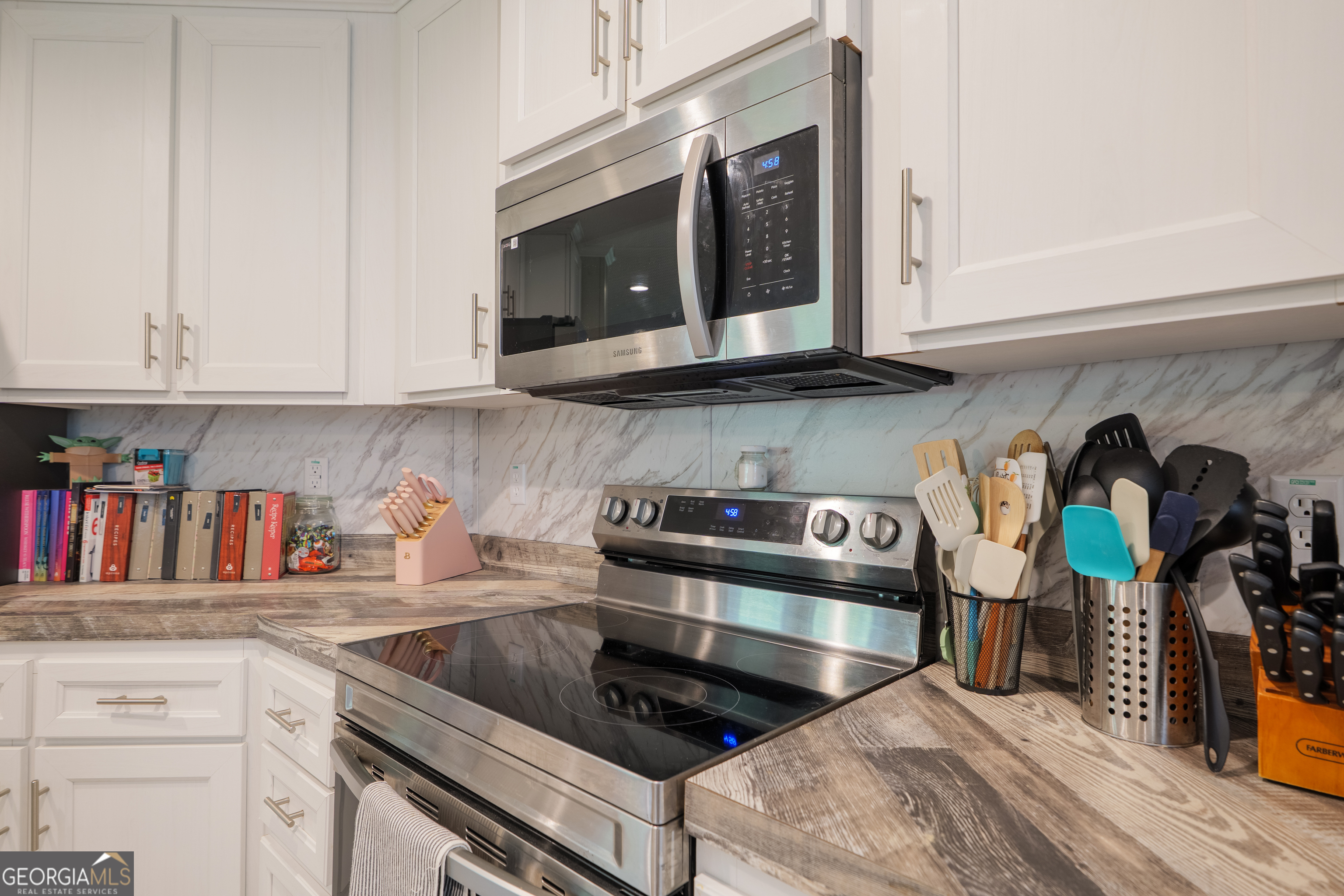 6054 Glenn Road Valdosta, GA 31606 - Photo 12 of 41 a kitchen with stainless steel appliances granite countertop a stove a microwave and cabinets