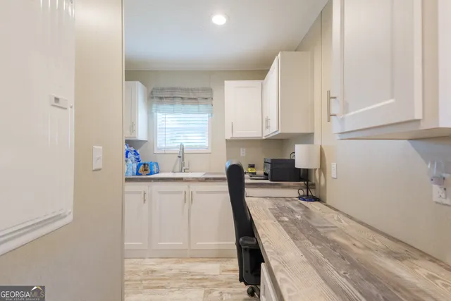 a kitchen with granite countertop a sink a stove and cabinets