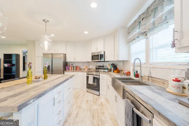 a kitchen with stainless steel appliances granite countertop a sink refrigerator and microwave