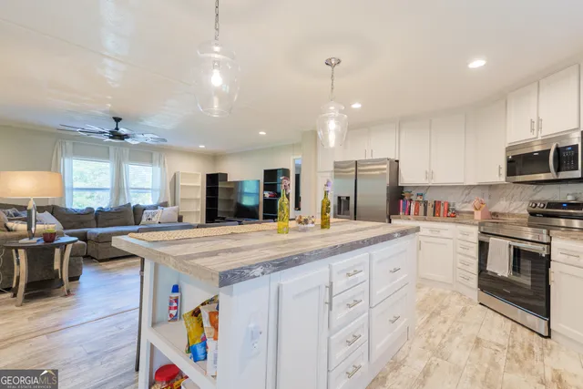 a kitchen with stainless steel appliances kitchen island granite countertop a stove and a sink