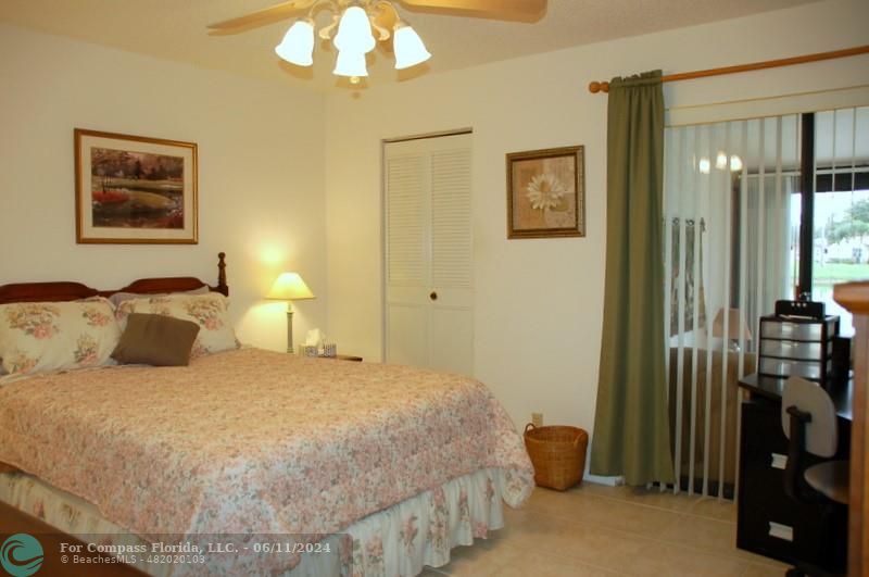 448 Pine Glen Lane, Unit E Greenacres, FL 33463 - Photo 12 of 35 a bedroom with a bed and a chandelier