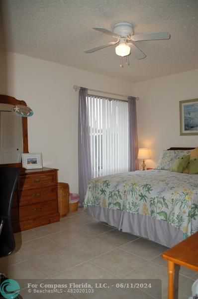448 Pine Glen Lane, Unit E Greenacres, FL 33463 - Photo 15 of 35 a bedroom with a bed and ceiling fan