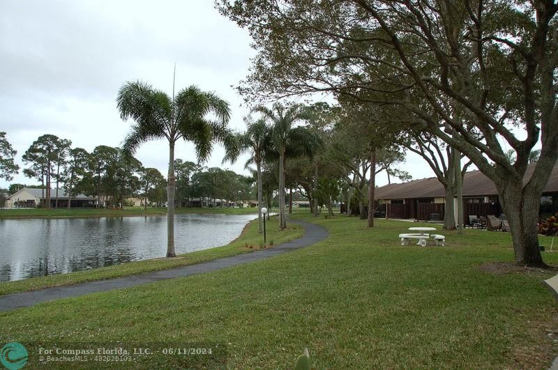 448 Pine Glen Lane, Unit E Greenacres, FL 33463 - Photo 24 of 35 a backyard of a house with lots of green space and lake view