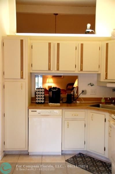 448 Pine Glen Lane, Unit E Greenacres, FL 33463 - Photo 9 of 35 a kitchen with stainless steel appliances a refrigerator a sink and cabinets