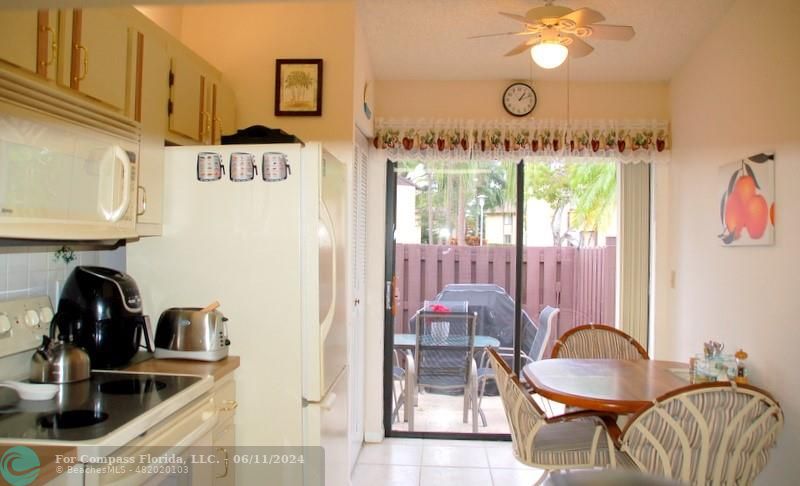 448 Pine Glen Lane, Unit E Greenacres, FL 33463 - Photo 10 of 35 a table chair sitting in a kitchen next to a window