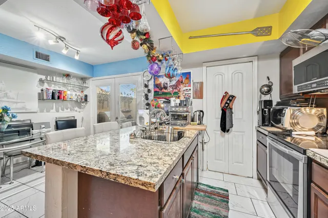 a kitchen with stainless steel appliances granite countertop a sink stove and refrigerator