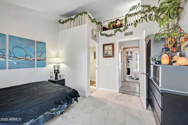 a bedroom with a bed and a large mirror on the dresser