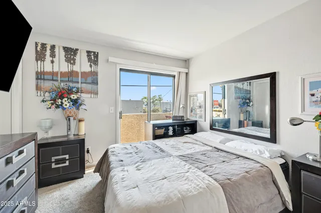 a bedroom with a bed and a potted plant on the dresser