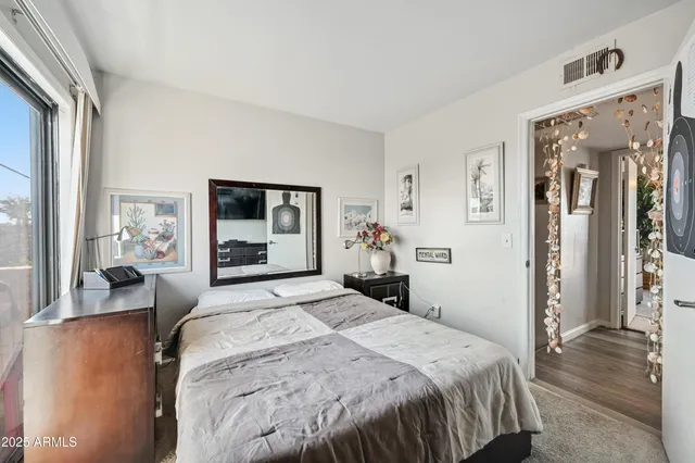 a bedroom with a large bed and a large mirror