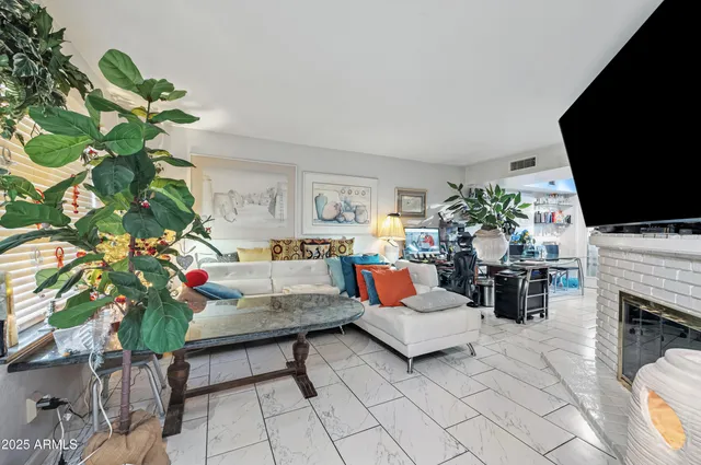 a living room with furniture a flat screen tv and a fireplace