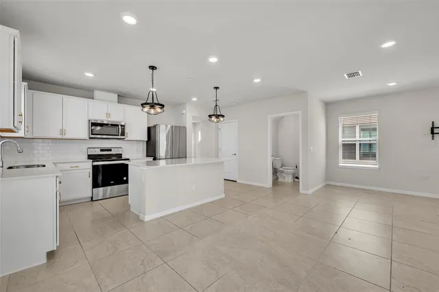 a large kitchen with cabinets and stainless steel appliances