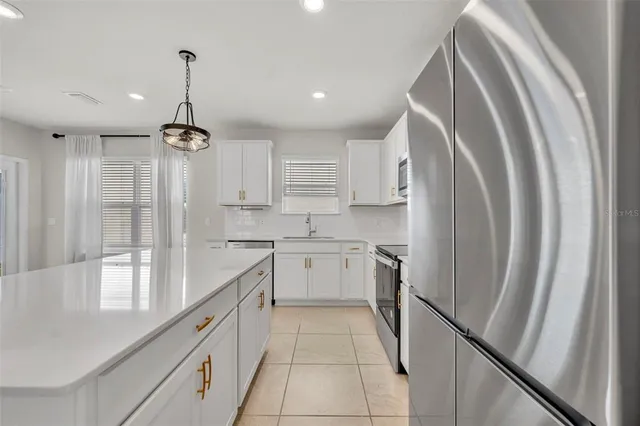 a kitchen with stainless steel appliances a refrigerator sink and cabinets