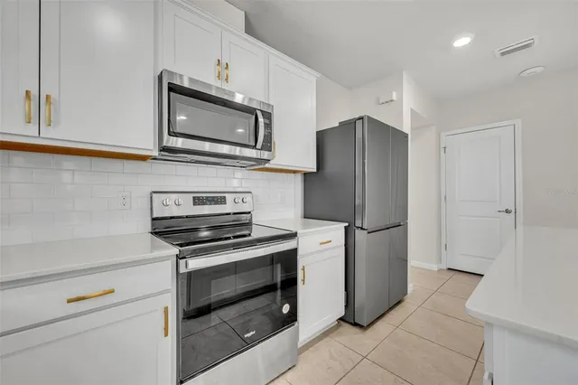 a kitchen with a refrigerator stove and microwave