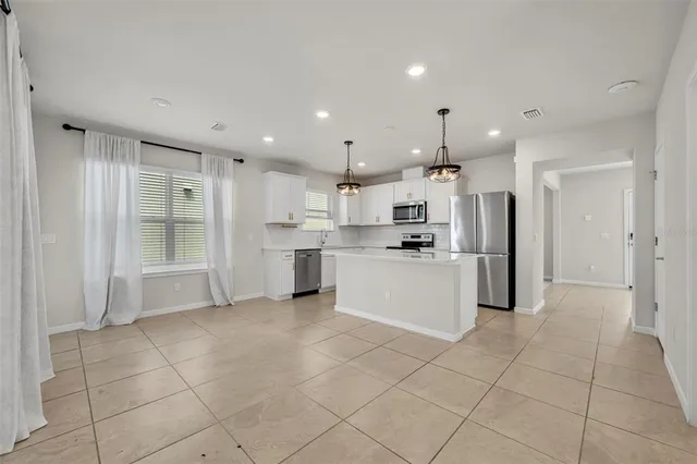 a large white kitchen with cabinets and stainless steel appliances